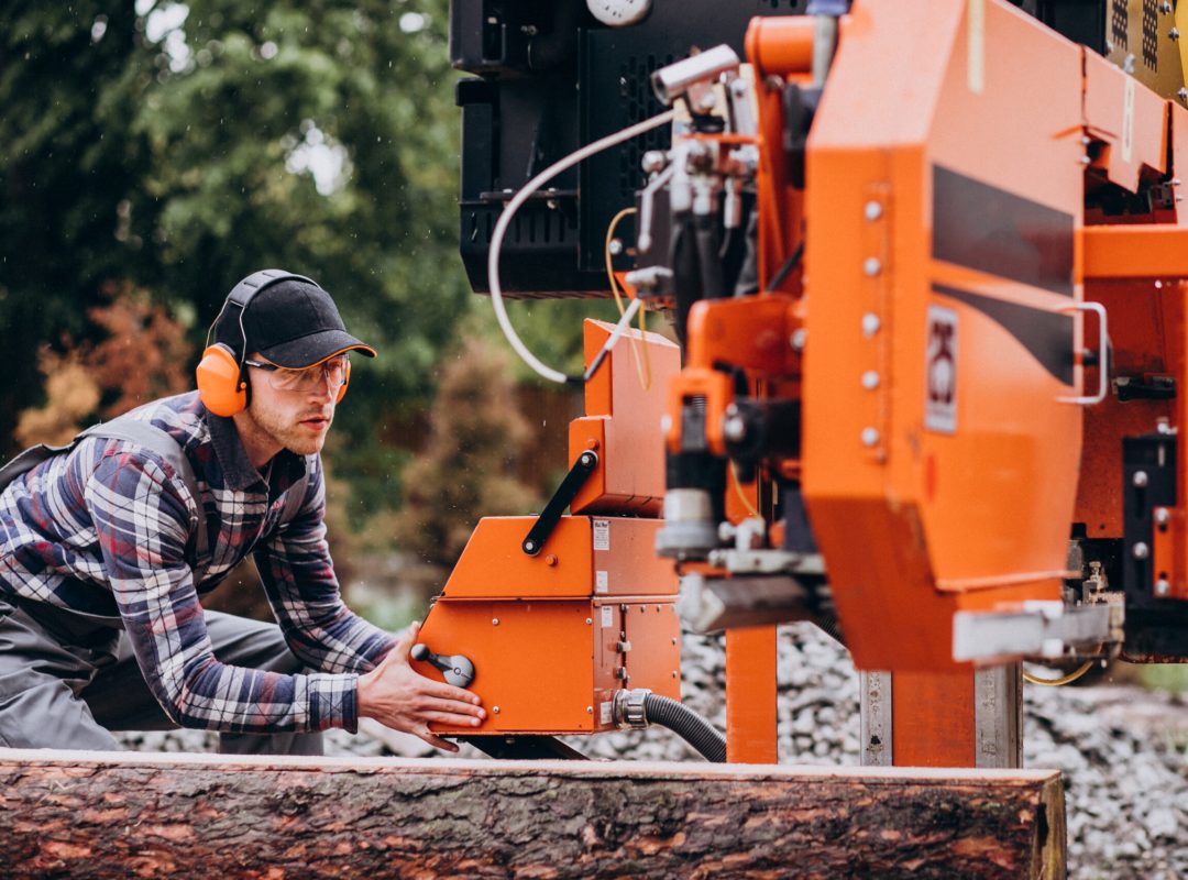 Carpenter working on a sawmill on a wood manufacture